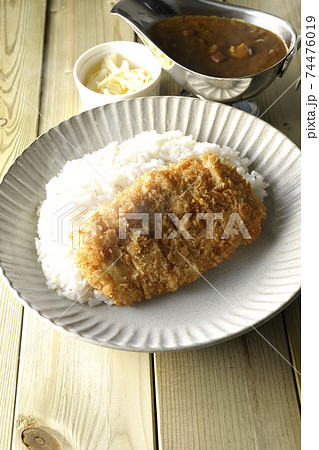 豚カツが乗った熱々ご飯とルーが入ったカレーポットとトッピングのナチュラルチーズ 74476019