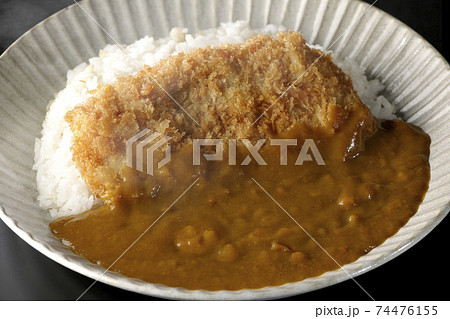 大きい豚カツが真ん中に一枚乗っているカツカレーを黒背景で撮影 大きい豚カツが真ん中に一枚乗っているカツカレーを黒背景で撮影 74476155