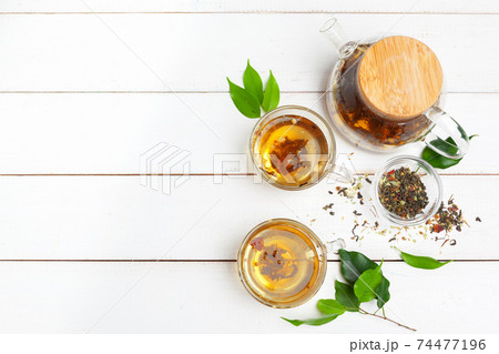 teapot and cups of tea on a white wooden background 74477196