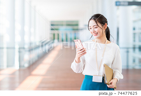 スマホを持つオフィスのビジネスウーマン　 74477625
