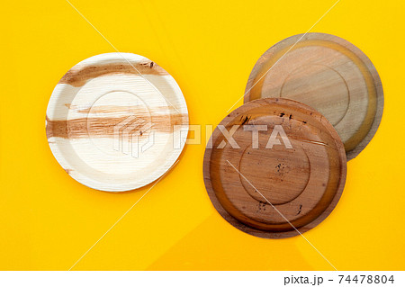Betel palm leaf plate on yellow background. 74478804