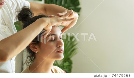Face massage treatment in the spa salon, Girl receiving holistic massage treatment. 74479563