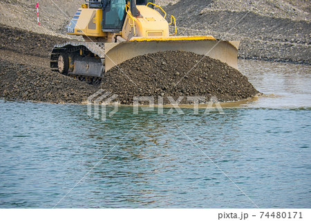 河川敷で敷均しをする重機 74480171