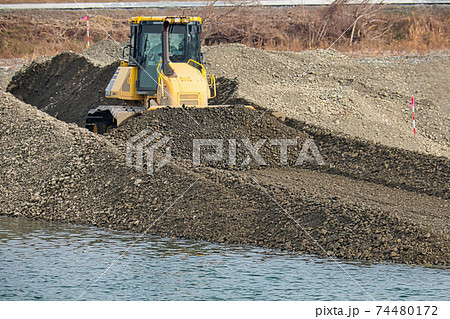 河川敷で敷均しをする重機 74480172