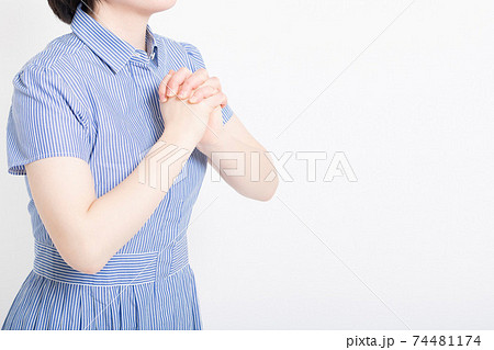 お願いのジェスチャーをするワンピースを着た女性 74481174