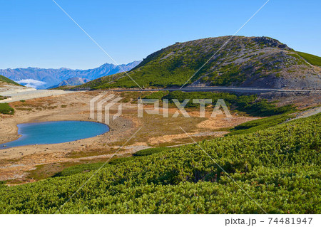 岐阜県(長野県)乗鞍岳の富士見岳の麓から鶴ヶ池と北アルプス(槍ヶ岳など)方面を見る 74481947