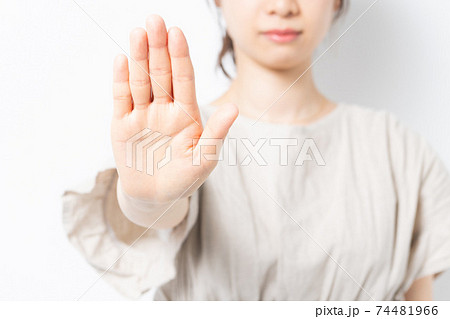 白背景の前に立って、NGのジェスチャーをする若い女性 白背景の前に立って、NGのジェスチャーをする若い女性 74481966