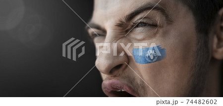 A screaming man with the image of the Food and agriculture organization national flag on his face 74482602