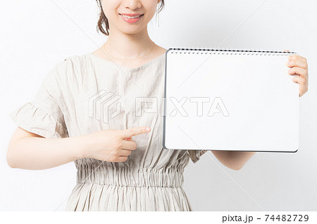 白背景の前でスケッチブックを持つ若い女性 白背景の前でスケッチブックを持つ若い女性 74482729