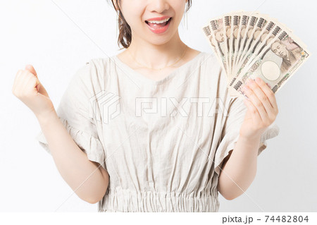 白背景の前に立ってお金を持っている若い女性 白背景の前に立ってお金を持っている若い女性 74482804