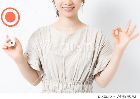 白背景の前でOKのプラカードを持つ若い女性 白背景の前でOKのプラカードを持つ若い女性 74484042