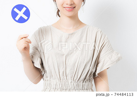 白背景の前でNGのプラカードを持っている若い女性 74484113