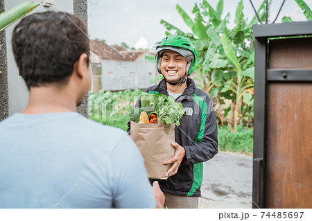 courier delivering grocery to customer 74485697