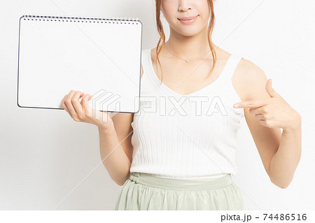 白背景の前でスケッチブックを持つ若い女性の写真素材 [74486516] - PIXTA