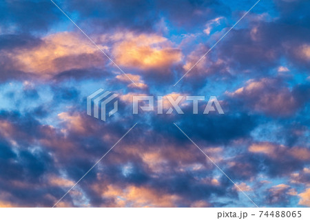 Beautiful clouds in blue sky, illuminated by rays of sun at colorful sunset to change weather. Summer cloudscape background 74488065