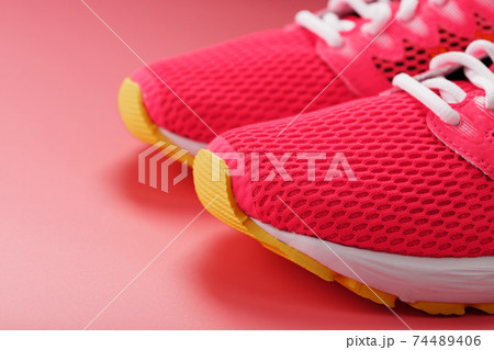 Jogging pink sneakers on a pink background with free space. Jogging pink sneakers on a pink background with free space. 74489406