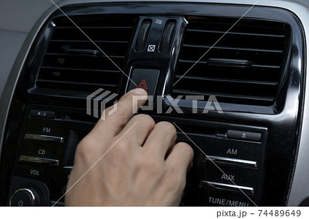 Close up hand press the emergency light in the car, Fingers press button.for open the contract emergency light in car. Emergency button press for open emergency light warning sign symbol out side car Close up hand press the emergency light in the car, Fingers press button.for open the contract emergency light in car. Emergency button press for open emergency light warning sign symbol out side car 74489649