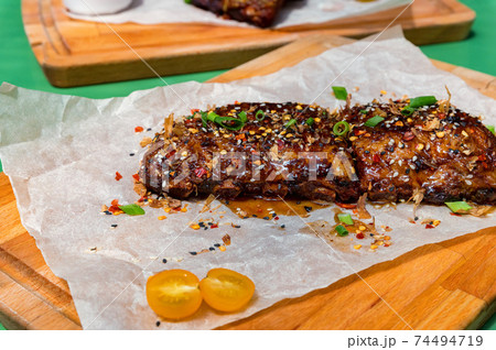 Close up board with pork ribs grilled with BBQ sauce, peanuts and jalapeno Close up board with pork ribs grilled with BBQ sauce, peanuts and jalapeno 74494719