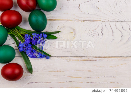 Painted Easter eggs and blue scilla flowers on white wooden background. Easter composition. Top view, copy space Painted Easter eggs and blue scilla flowers on white wooden background. Easter composition. Top view, copy space 74495895