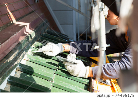 新しく漆喰を塗り直す屋根職人 74496178