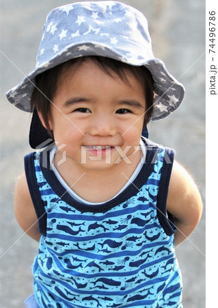 チューリップハットをかぶりタンクトップで散歩する2歳の男の子 74496786