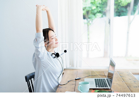 テレワークの合間にストレッチする若い女性 74497613