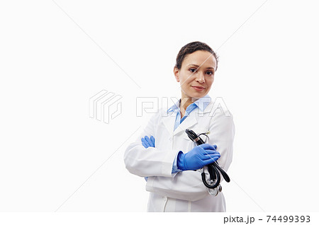 Confident portrait of a female doctor with stethoscope in hands isolated on white background with copy space. Confident portrait of a female doctor with stethoscope in hands isolated on white background with copy space. 74499393
