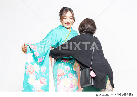 着物の着付けをしてもらう女性と、着付け師の女性 74499498