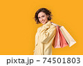 Young adult girl with shopping bags looking at camera 74501803