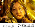 Teenager hipster girl with polyethylene film on head in vibrant neon light 74501813