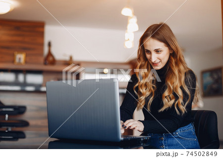 Beautiful woman sitting at home with laptop 74502849
