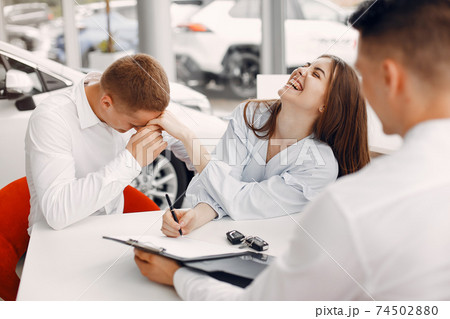 Stylish and elegant couple in a car salon 74502880