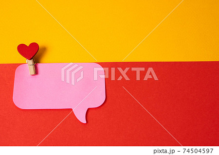 Red heart on a clothespin and a pink sticky note colorful background 74504597