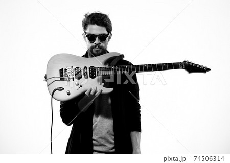 man with guitar in hands musician rock star performance lifestyle light background 74506314