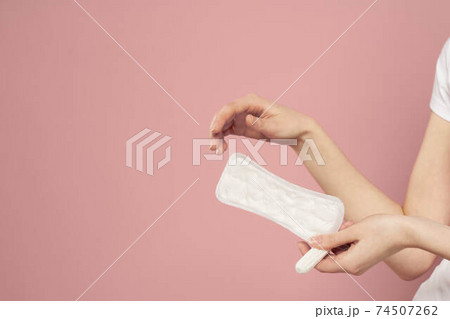Protective pad and tampon in female hands on a pink background menstruation critical days 74507262