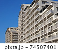 青空を背景にした白いマンション 74507401