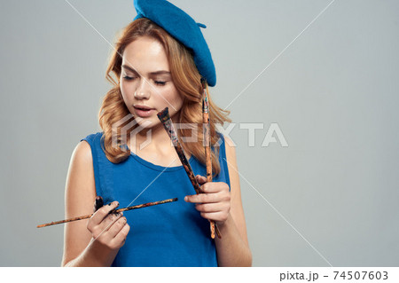 woman artist brush in hand blue beret dress hobby art lifestyle light background 74507603