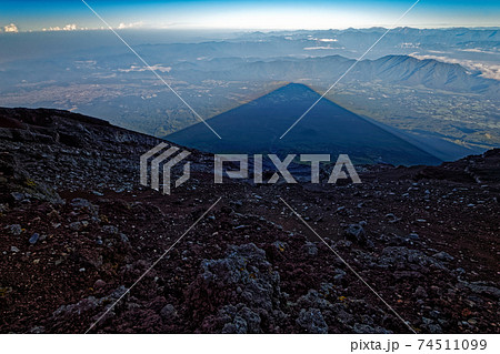 富士山山頂から見る朝霧高原に映る影富士と南アルプスの山並みの写真素材