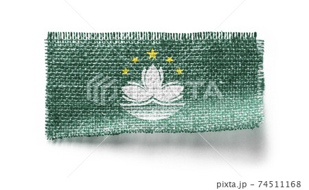 Macao flag on a piece of cloth on a white background 74511168