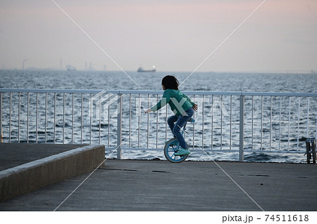 海岸で一輪車乗りの練習の女の子の写真素材