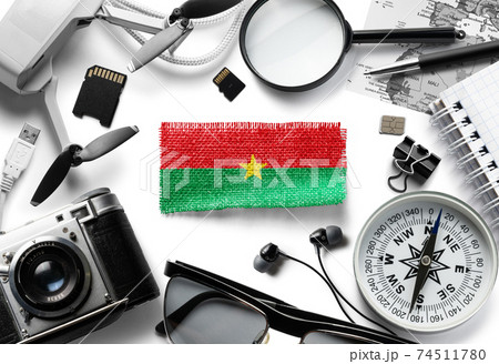 Flag of Burkina Faso and travel accessories on a white background. Flag of Burkina Faso and travel accessories on a white background. 74511780