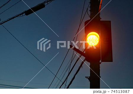 夕暮れの黄信号になった予告灯のある風景の写真素材