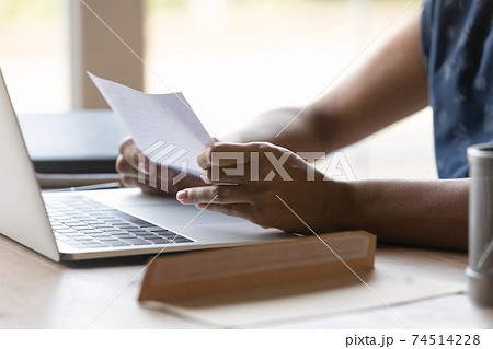Close up African American woman reading letter at home 74514228