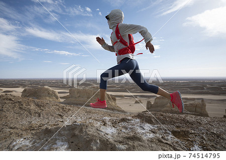 Woman trail runner cross country running  on sand desert dunes 74514795