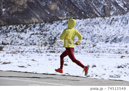 Woman trail runner  cross country running  in winter mountains 74515549