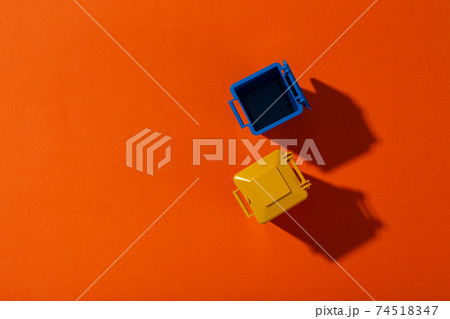 Yellow and blue trash can on an orange background. Infection control concept. Yellow and blue trash can on an orange background. Infection control concept. 74518347