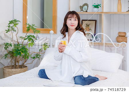 ベッドでヨーグルトを食べる若い女性 ベッドでヨーグルトを食べる若い女性 74518729