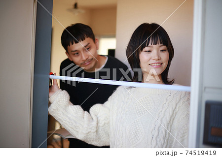 玄関ドアの幅を測る夫婦 玄関ドアの幅を測る夫婦 74519419
