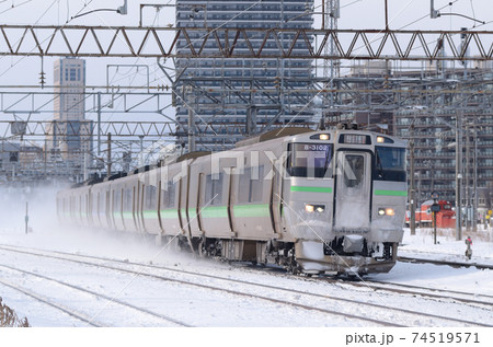 雪煙を上げて苗穂駅を通過していく快速「エアポート」 74519571