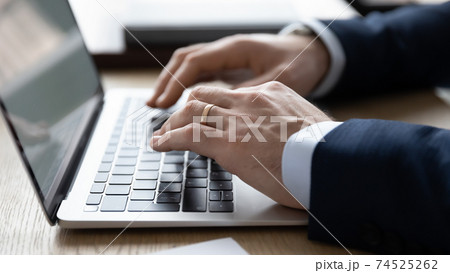 Close up of businessman typing on modern laptop Close up of businessman typing on modern laptop 74525262